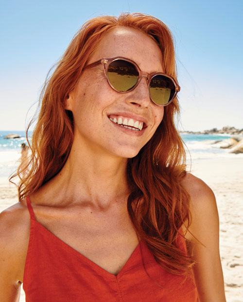 Woman on the beach wearing Crizal Sun XProtect sunglasses