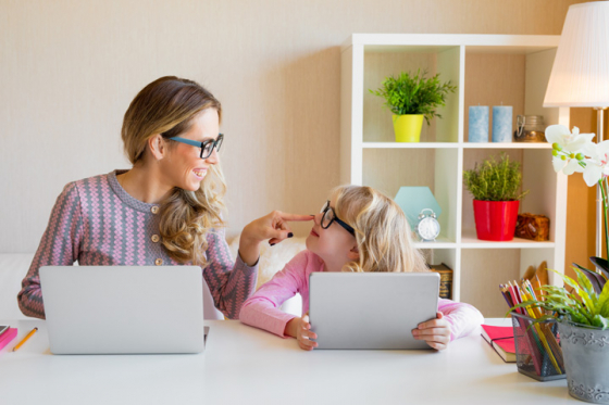 Mother and daughter wearing glasses looking at laptop