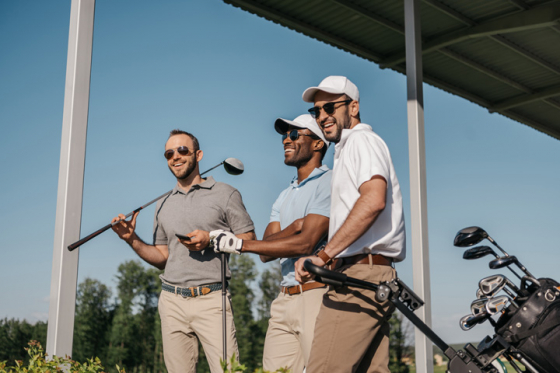 Three men wearing sunglasses playing golf