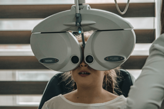 a child having her eyes tested on a phoropter