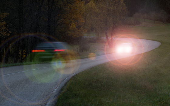Cars driving at night with flared headlights